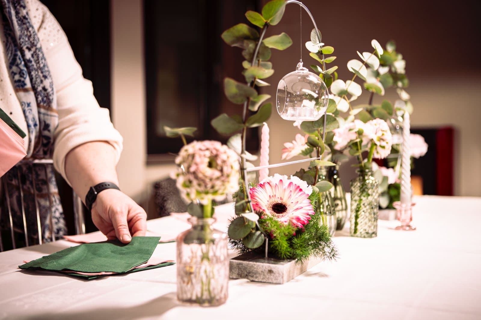 Allestimento tavolo con composizioni floreali ed eucalipto