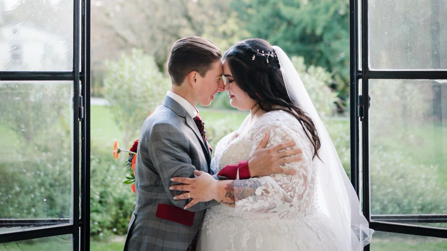 Abbraccio degli sposi nella serra tra il verde